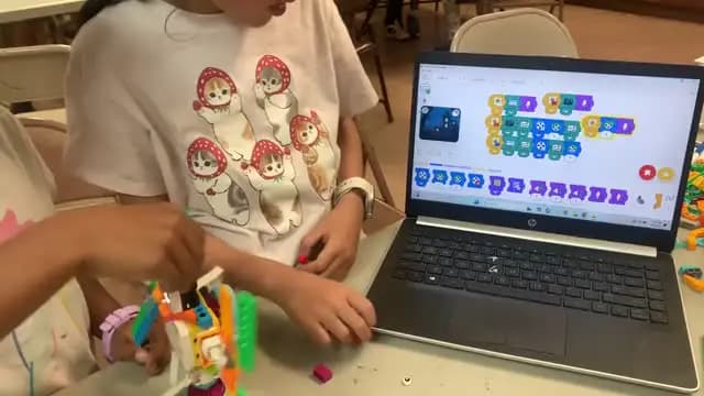 Camper coding on a laptop in Scratch